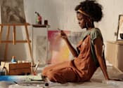 Thumbnail 1 of 22 - A woman artist painting in a studio.