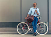 Thumbnail 22 of 22 - A man is standing next to a bicycle holding a phone.