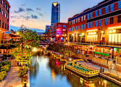 Thumbnail 16 of 22 - A boat is docked at a canal in a city.