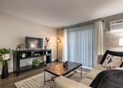 Thumbnail 36 of 65 - A living room with a television, a couch, a coffee table, and a plant in a 1 bedroom, 1 bath 560 square foot apartment at Aspen Village Apartments in the Westwood neighborhood of Cincinnati, OH.