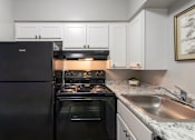 Thumbnail 35 of 65 - A black refrigerator is in a kitchen with a stove and oven in a 1 bedroom, 1 bath 560 square foot apartment at Aspen Village Apartments in the Westwood neighborhood of Cincinnati, OH.