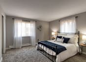 Thumbnail 42 of 65 - A bedroom with a bed, nightstands, and a window with curtains in a 1 bedroom, 1 bath 560 square foot apartment at Aspen Village Apartments in the Westwood neighborhood of Cincinnati, OH.