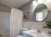 Thumbnail 44 of 65 - A bathroom with a white shower curtain and a white toilet in a 1 bedroom, 1 bath 560 square foot apartment at Aspen Village Apartments in the Westwood neighborhood of Cincinnati, OH.