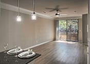 Thumbnail 3 of 61 - Open-concept living and dining area with wood-look flooring, ceiling fan, and sliding glass door in a one-bedroom apartment home