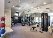 Thumbnail 36 of 52 - The 24-hour fitness center with a variety of equipment including free weights and cardio machines. at The Brownstones Townhome Apartments in the Far North Dallas neighborhood of Dallas, TX.