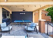 Thumbnail 40 of 52 - A pool table with a sign that says "Game On" is surrounded by chairs.