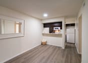 Thumbnail 20 of 62 - View of the dining area with large mirror looking into a kitchen with dark wood cabinets and white appliances in a 1 bedroom, 1 bath B, 629 sq ft apartment home at The Biltmore Apartments located in the Vickery Midtown neighborhood of Dallas, TX.