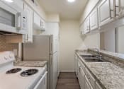 Thumbnail 13 of 62 - Kitchen with white cabinets and white appliances in a 2 bedroom, 1.5 bath 846 sq ft apartment home at The Biltmore Apartments located in the Vickery Midtown neighborhood of Dallas, TX.