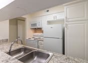 Thumbnail 14 of 62 - Kitchen with white cabinets and white appliances in a 2 bedroom, 1.5 bath 846 sq ft apartment home at The Biltmore Apartments located in the Vickery Midtown neighborhood of Dallas, TX.