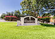 Thumbnail 28 of 42 - A sign for Cambridge Apartment Homes is in a grassy area in front of Cambridge Court Apartments Entryway in Lake Highlands, Dallas, TX.
