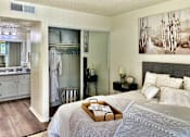 Thumbnail 12 of 47 - Sleeping and living area in an Efficiency apartment at Cambridge Court Apartments in Dallas, Texas, showing the bed area, and access toward the bathroom and closet.