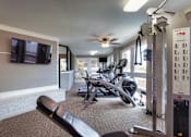 Thumbnail 26 of 42 - The fitness center with rowing machine, elliptical, treadmill, bike, weight system and free weights at Cambridge Court Apartments in Lake Highlands, Dallas, TX.