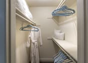 Thumbnail 24 of 47 - Walk-in closet in a 1-bedroom apartment at Cambridge Court Apartments in Dallas, Texas, showing built-in shelving and hanging space.