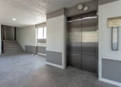 Thumbnail 37 of 42 - This is a photo of an elevatorin an open air hallway with new tile in the 450 square foot efficiency apartment at Cambridge Court Apartments in Dallas, TX.