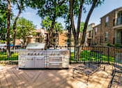 Thumbnail 29 of 40 - BBQ area with grill and lounge chairs at Canyon Creek Apartments in the Dallas Midtown neighborhood of Dallas, TX.