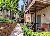 Thumbnail 36 of 40 - Walkway through apartment complex at Canyon Creek Apartments in the Dallas Midtown neighborhood of Dallas, TX.