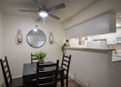 Thumbnail 14 of 40 - A dining room with a table and chairs in a 515 square foot 1 bedroom, 1 bath apartment home at Canyon Creek Apartments in Dallas Midtown neighborhood of Dallas, TX.