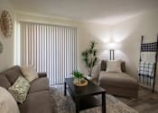 Thumbnail 16 of 40 - Living room with a couch, chaise lounge and a potted plant in a 515 square foot 1 bedroom, 1 bath apartment home at Canyon Creek Apartments in Dallas Midtown neighborhood of Dallas, TX.