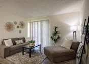 Thumbnail 17 of 40 - Living room with a couch, chaise lounge and a potted plant in a 515 square foot 1 bedroom, 1 bath apartment home at Canyon Creek Apartments in Dallas Midtown neighborhood of Dallas, TX.