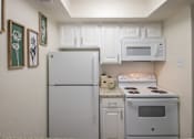 Thumbnail 3 of 40 - A kitchen with a white cabinets and appliances in a 515 square foot 1 bedroom, 1 bath apartment home at Canyon Creek Apartments in Dallas Midtown neighborhood of Dallas, TX.