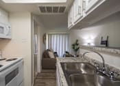 Thumbnail 4 of 40 - A kitchen with a white cabinets and appliances in a 515 square foot 1 bedroom, 1 bath apartment home at Canyon Creek Apartments in Dallas Midtown neighborhood of Dallas, TX.