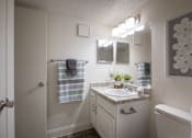 Thumbnail 23 of 40 - A bathroom with a white vanity in a 515 square foot 1 bedroom, 1 bath apartment home at Canyon Creek Apartments in Dallas Midtown neighborhood of Dallas, TX.