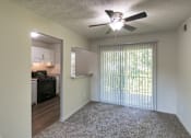 Thumbnail 9 of 41 - Open living and dining area with ceiling fan and sliding glass door in an 880-square-foot apartment home