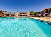 Thumbnail 11 of 41 - inviting swimming pool and lounge chairs at Compton Lake Apartments on a sunny day