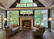 Thumbnail 68 of 74 - A living room with a fireplace and two chairs.