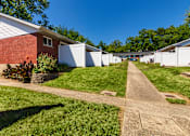 Thumbnail 69 of 71 - Sidewalk leading past private patios and grassy lawn at Colonial Ridge Apartments