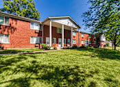 Thumbnail 62 of 71 - Two-story brick apartment buildings with mature trees and landscaped courtyard