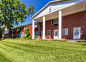 Thumbnail 68 of 71 - Two-story apartment building exterior with white columns and broad green lawn