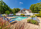 Thumbnail 56 of 82 - A pool surrounded by blue lounge chairs at Fairfield Pointe Apartments in Fairfield, Ohio.