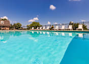 Thumbnail 59 of 82 - A pool surrounded by white lounge chairs at Fairfield Pointe Apartments in Fairfield, Ohio.