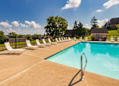 Thumbnail 60 of 82 - A pool surrounded by white lounge chairs at Fairfield Pointe Apartments in Fairfield, Ohio.