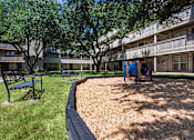 Thumbnail 39 of 43 - This is a photo of a couple of benches by the playground in the courtyard at Harvard Square Apartments, in the Vickery Meadow neighborhood of Dallas, TX.