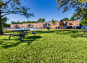 Thumbnail 42 of 46 - Community lawn with picnic tables, bbq grill and apartment buildings at Lisa Ridge Apartments on the west side of Cincinnati