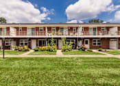 Thumbnail 59 of 59 - Two-story apartment building with private balcony, landscaped lawn, and central walkway at Lake of the Woods Apartments