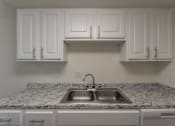 Thumbnail 28 of 62 - A kitchen with white cabinets at Princeton Court Apartments in the Vickery Midtown neighborhood of Dallas, TX.
