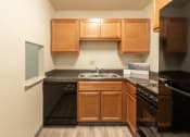 Thumbnail 18 of 78 - This is a photo of a kitchen with honey oak cabinets and black appliances in a 560 square foot 1, 1 bath apartment at Park Lane Apartments in Cincinnati, OH.