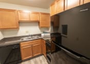 Thumbnail 19 of 78 - This is a photo of a kitchen with honey oak cabinets and black appliances in a 560 square foot 1, 1 bath apartment at Park Lane Apartments in Cincinnati, OH.
