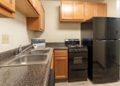 Thumbnail 17 of 78 - This is a photo of a kitchen with honey oak cabinets and black appliances in a 560 square foot 1, 1 bath apartment at Park Lane Apartments in Cincinnati, OH.