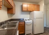 Thumbnail 13 of 78 - This is a photo of a kitchen with honey oak cabinets and white appliances in a 560 square foot 1, 1 bath apartment at Park Lane Apartments in Cincinnati, OH.