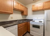 Thumbnail 4 of 78 - This is a photo of a kitchen with honey oak cabinets and white appliances in a 560 square foot 1, 1 bath apartment at Park Lane Apartments in Cincinnati, OH.