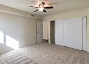 Thumbnail 28 of 38 - A room with a ceiling fan and carpeted floor.