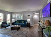 Thumbnail 37 of 44 - The leasing office with a blue couch and a television on the wall at The Summit at Midtown Apartments in Midtown, Dallas, TX.
