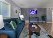 Thumbnail 38 of 44 - The leasing office with a blue couch and a television on the wall at The Summit at Midtown Apartments in Midtown, Dallas, TX.
