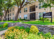 Thumbnail 39 of 44 - Building exterior and sign directing to the leasing office at The Summit at Midtown Apartments in Midtown, Dallas, TX.