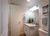 Thumbnail 12 of 44 - A bathroom with a white vanity in the 558 square foot 1 bedroom, 1 bath model apartment at The Summit at Midtown Apartments in the Dallas Midtown neighborhood of Dallas, TX.