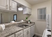 Thumbnail 4 of 43 - Kitchen with white cabinetry, granite-style countertops, double sink, and breakfast bar in the 558-square-foot 1 Bedroom, 1 Bath A at The Summit at Midtown